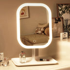 White vanity makeup mirror illuminated on a dressing table with its storage base visible.