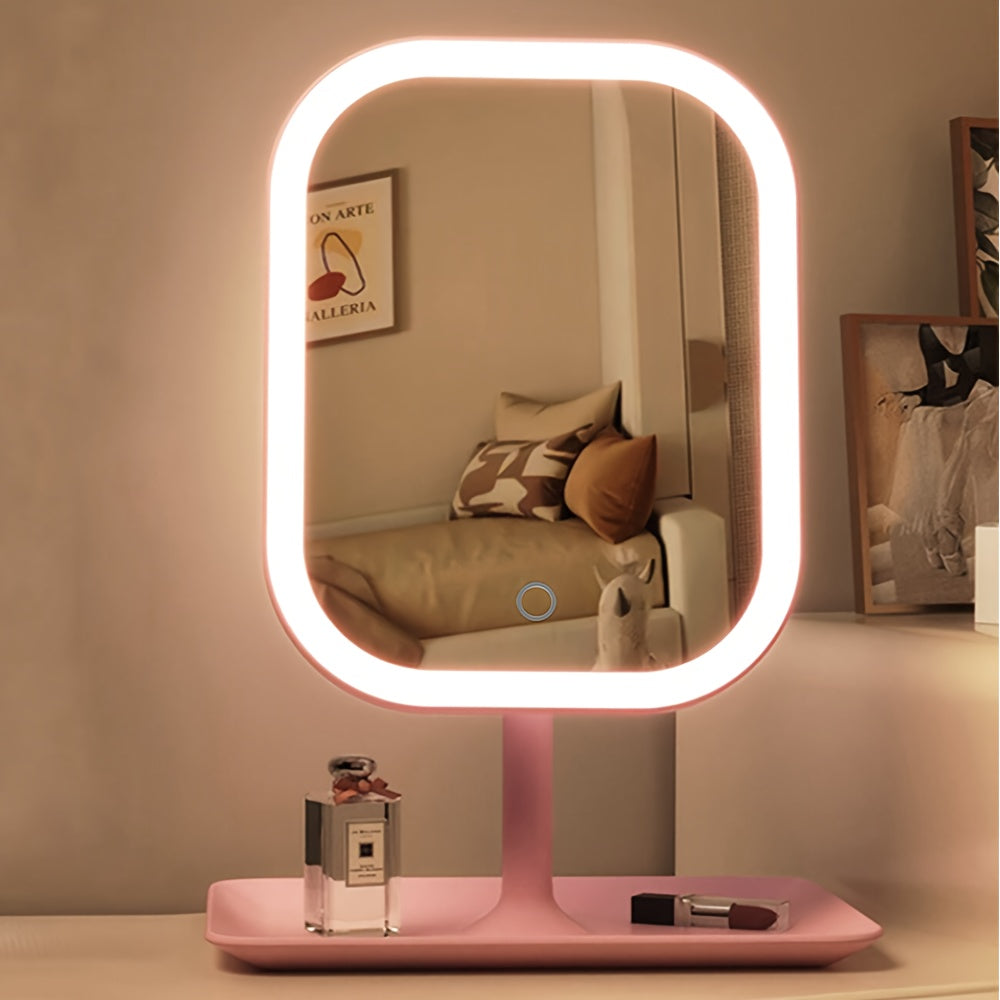 Pink vanity makeup mirror illuminated with warm light on a dressing table.