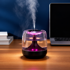 Black humidifier with pink lighting beside a laptop and books
