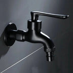 Wall-mounted faucet in a rounded matte black style with a hose connector against dark tile.