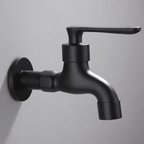 Wall-mounted faucet in a rounded matte black style mounted on a gray wall.