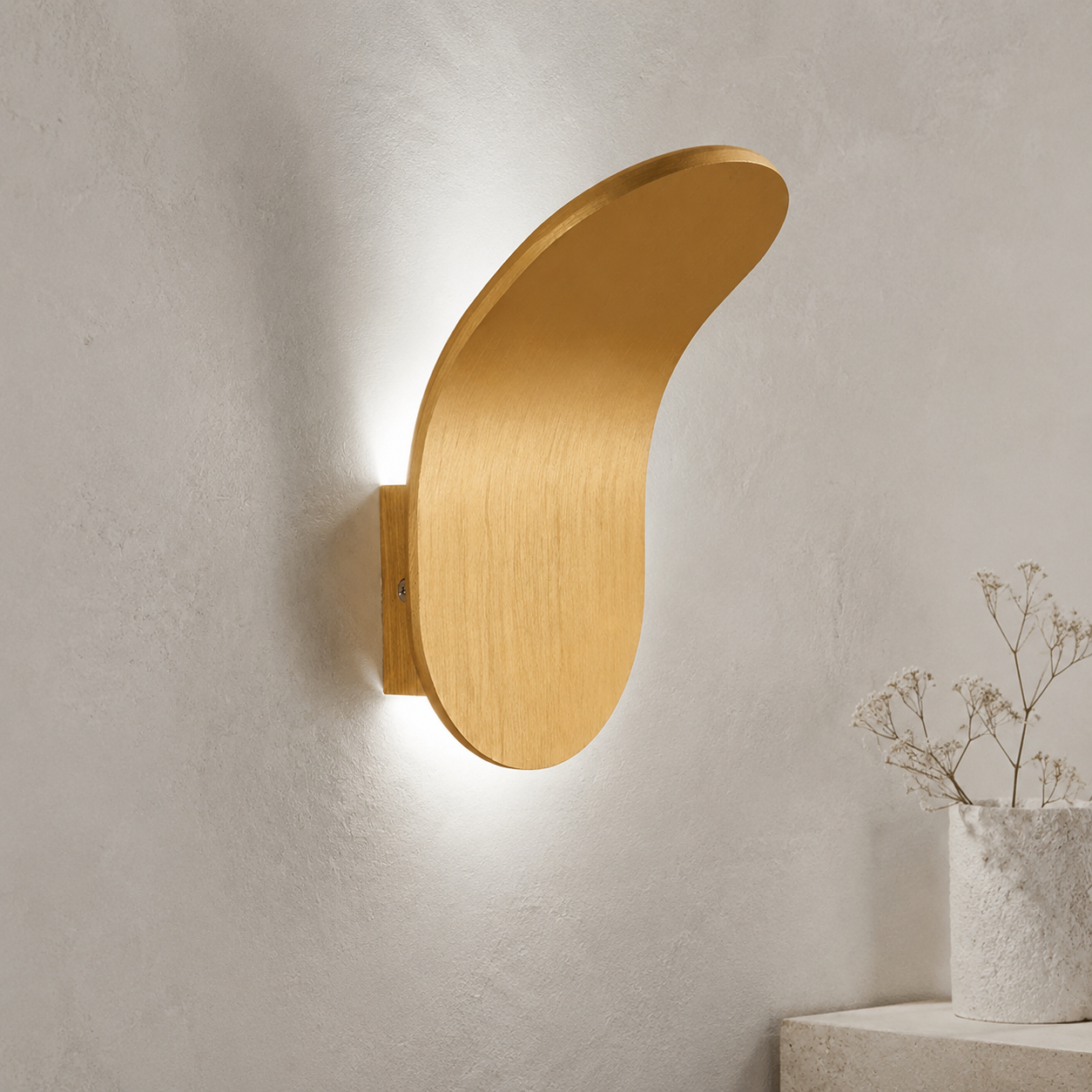Black curved wall sconce casting warm light above a wood console.