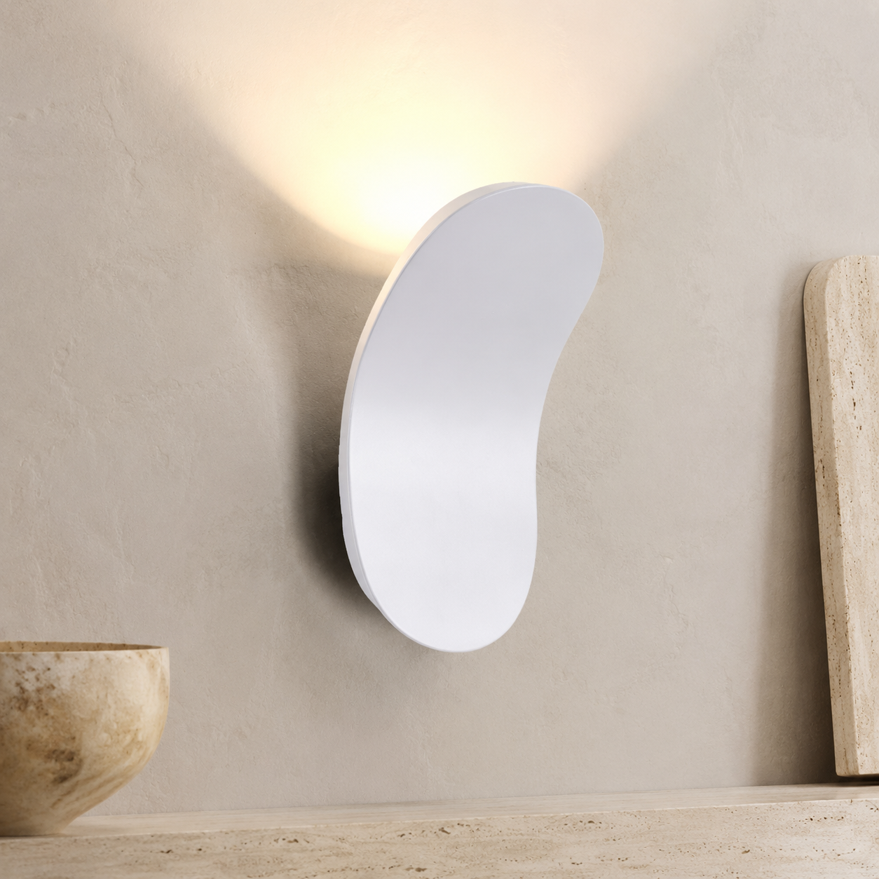 White curved wall sconce casting cool light above a stone console.
