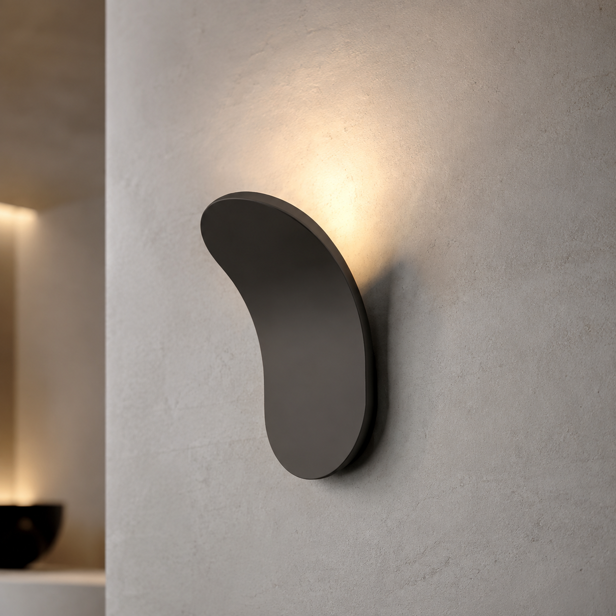 Gold curved wall sconce glowing warmly on a textured ivory wall.