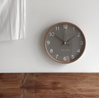 Gray wall clock in a wooden frame above a wood wall panel