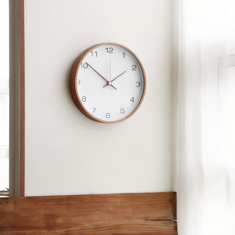 White wall clock in a wooden frame beside a window