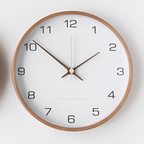 White wall clock with black numerals and a round wooden frame