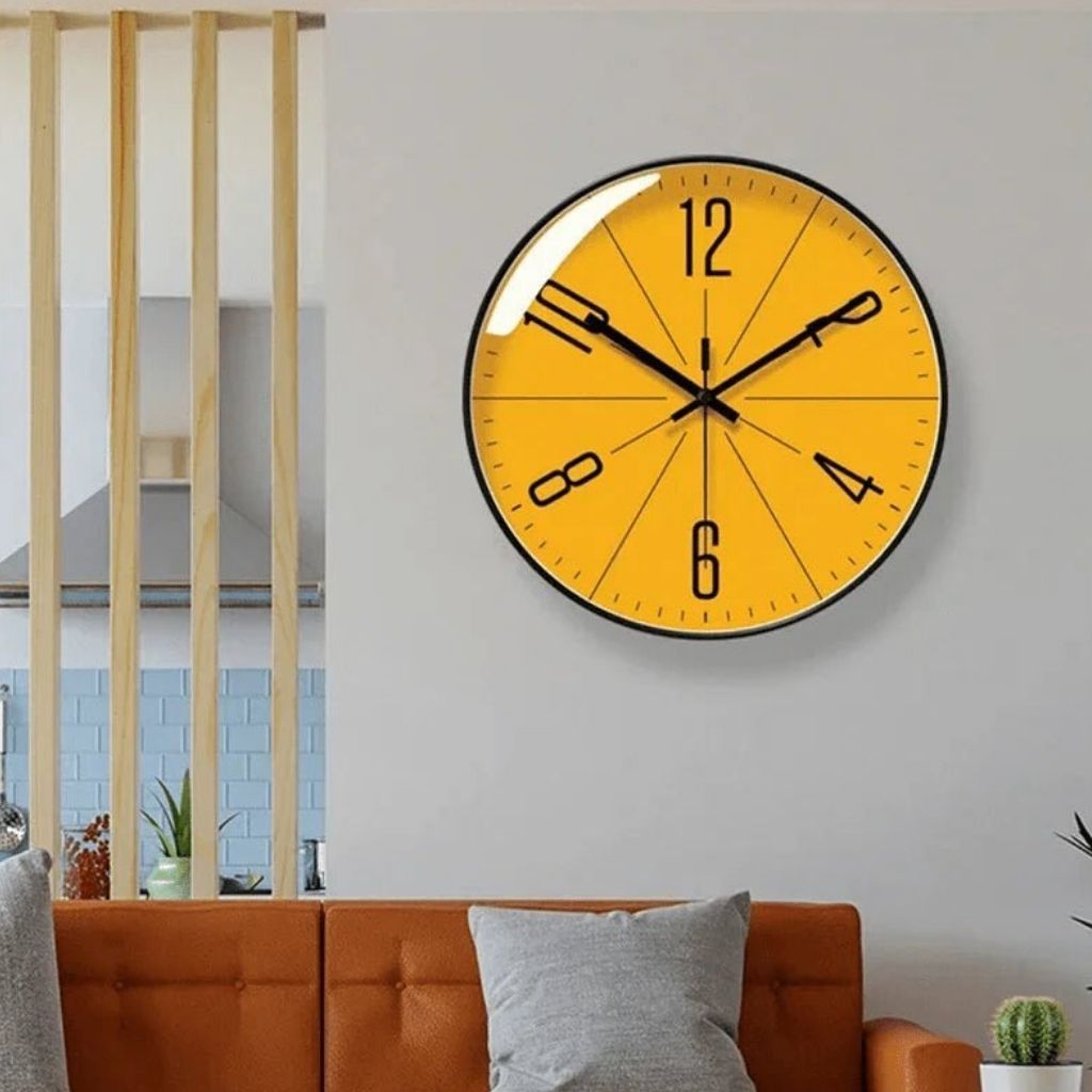 Black frame Nordic wall clock shown in a room.