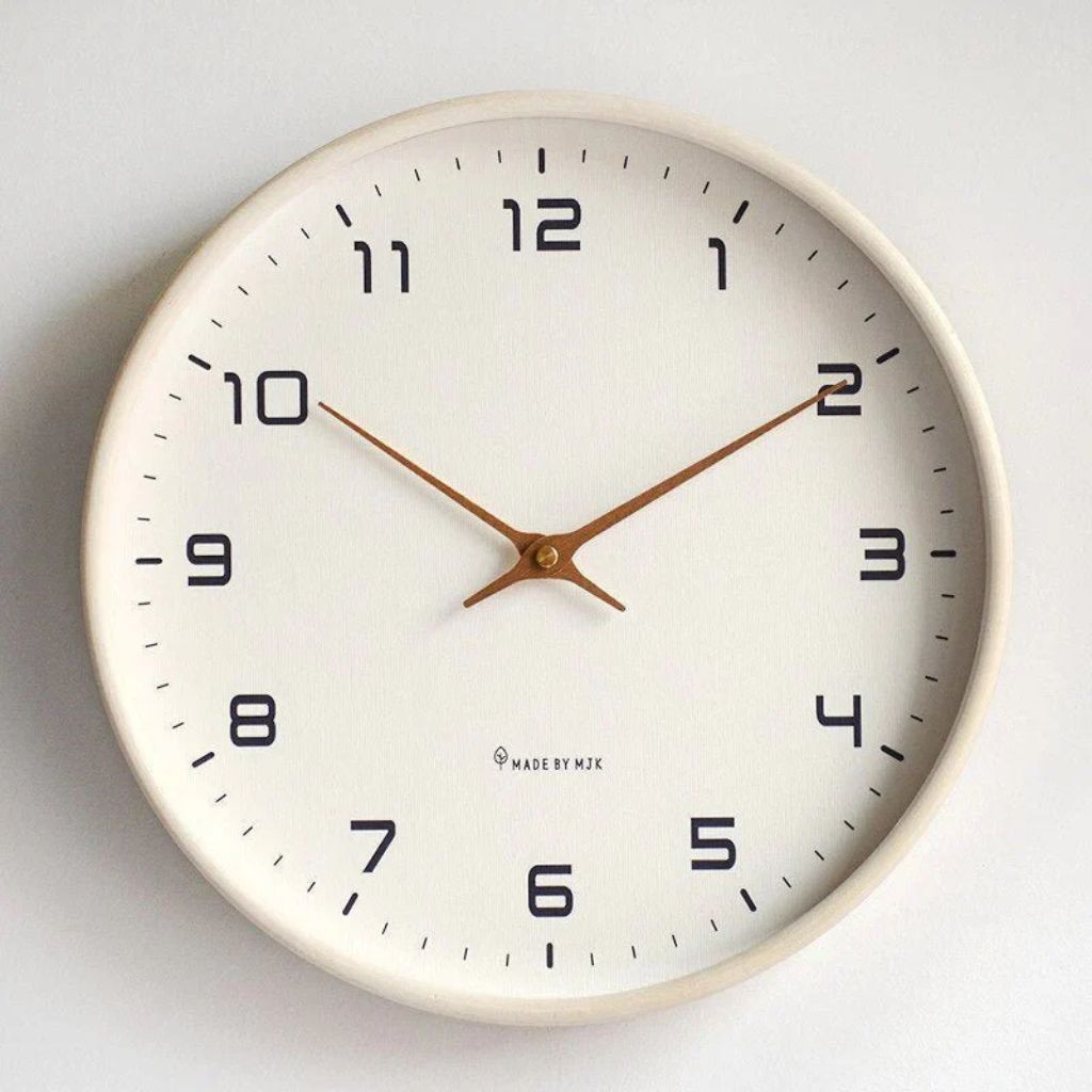 Scandinavian wall clock with cream dial and solid wood frame.