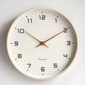 Scandinavian wall clock with cream dial and solid wood frame.