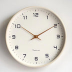 Scandinavian wall clock with cream dial and solid wood frame.