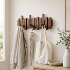 Walnut wall coat rack with folding piano key hooks holds a bag, umbrella, and light jacket.