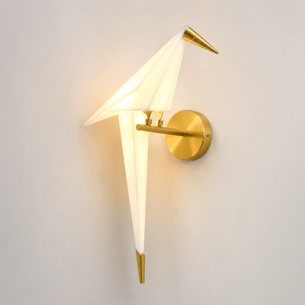Origami bird LED wall lamp glowing warm white with a translucent acrylic shade and brushed gold mount.