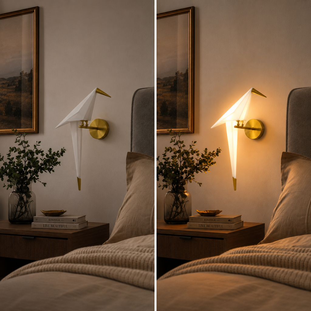 Origami bird LED wall lamp shown off and glowing warm white beside a bed in a cozy bedroom.