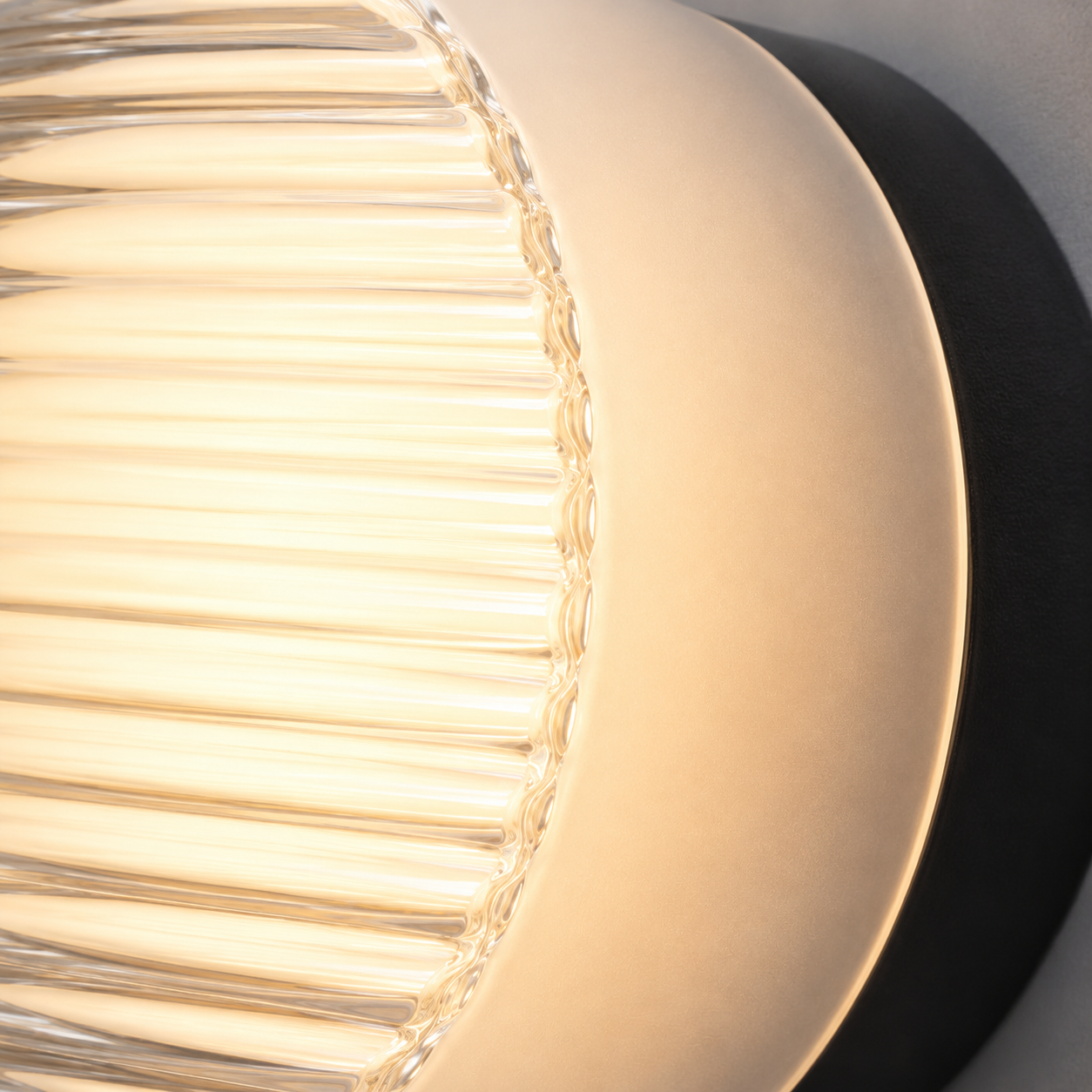 Close-up of a round ribbed LED wall lamp glowing warm white, showing the textured acrylic diffuser and black mounting base.