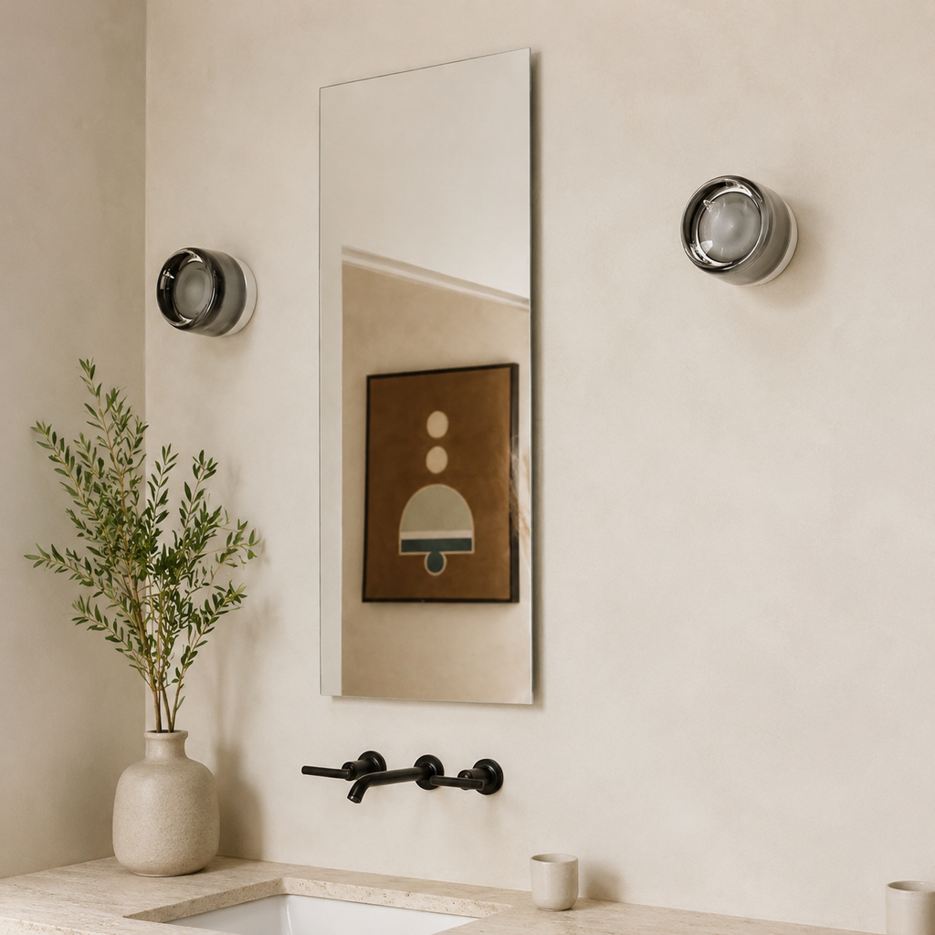 smoked round wall sconce beside a bathroom mirror