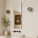 smoked round wall sconce beside a bathroom mirror