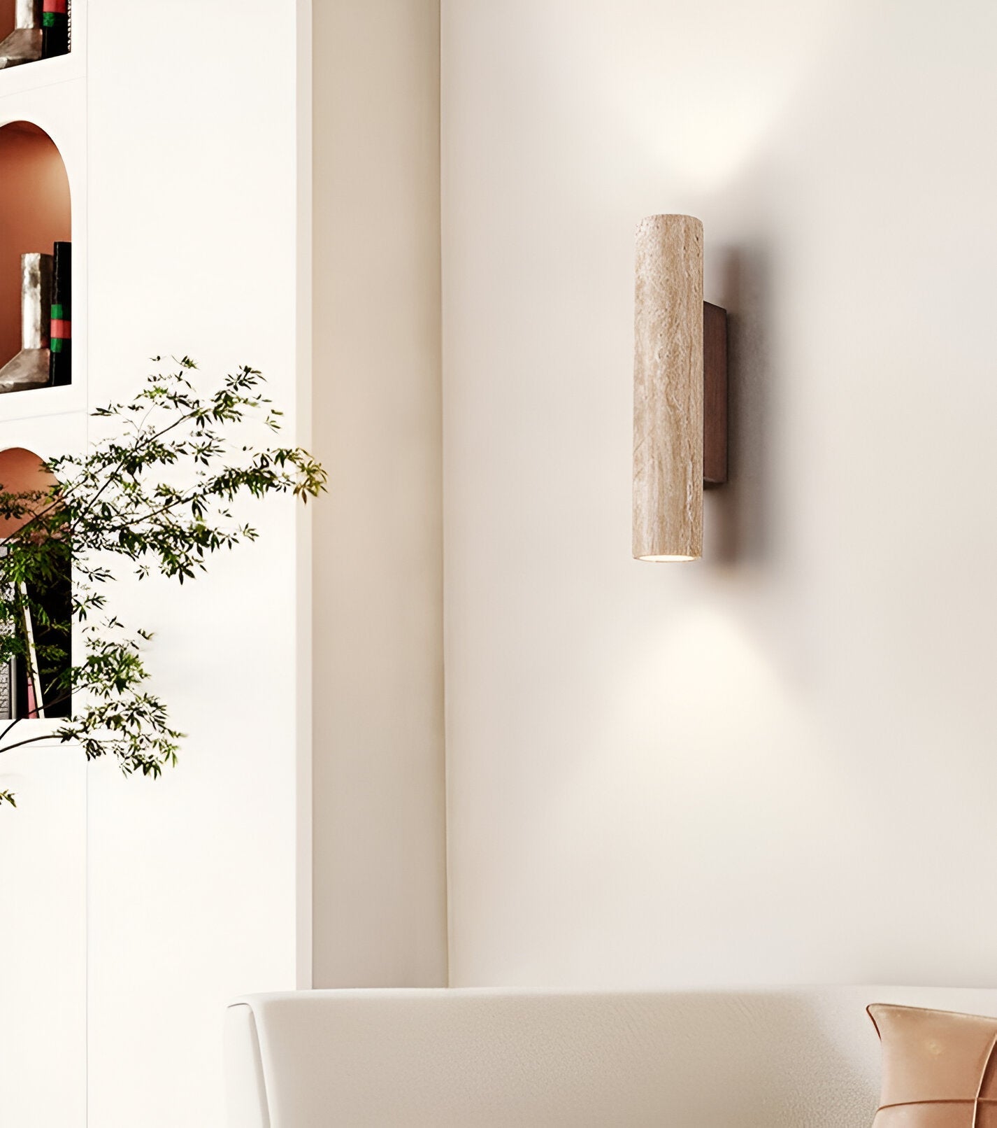 Cylindrical travertine wall sconce casting light above and below its natural stone shade