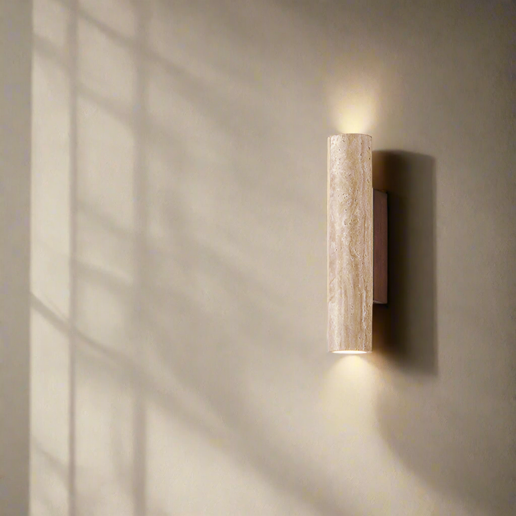 Cylindrical travertine wall sconce casting light above and below its natural stone shade