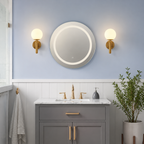 Two gold frosted globe wall sconces above a bathroom vanity.