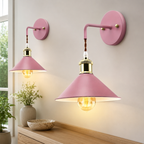 Two pink industrial wall sconce fixtures glowing on a neutral interior wall.