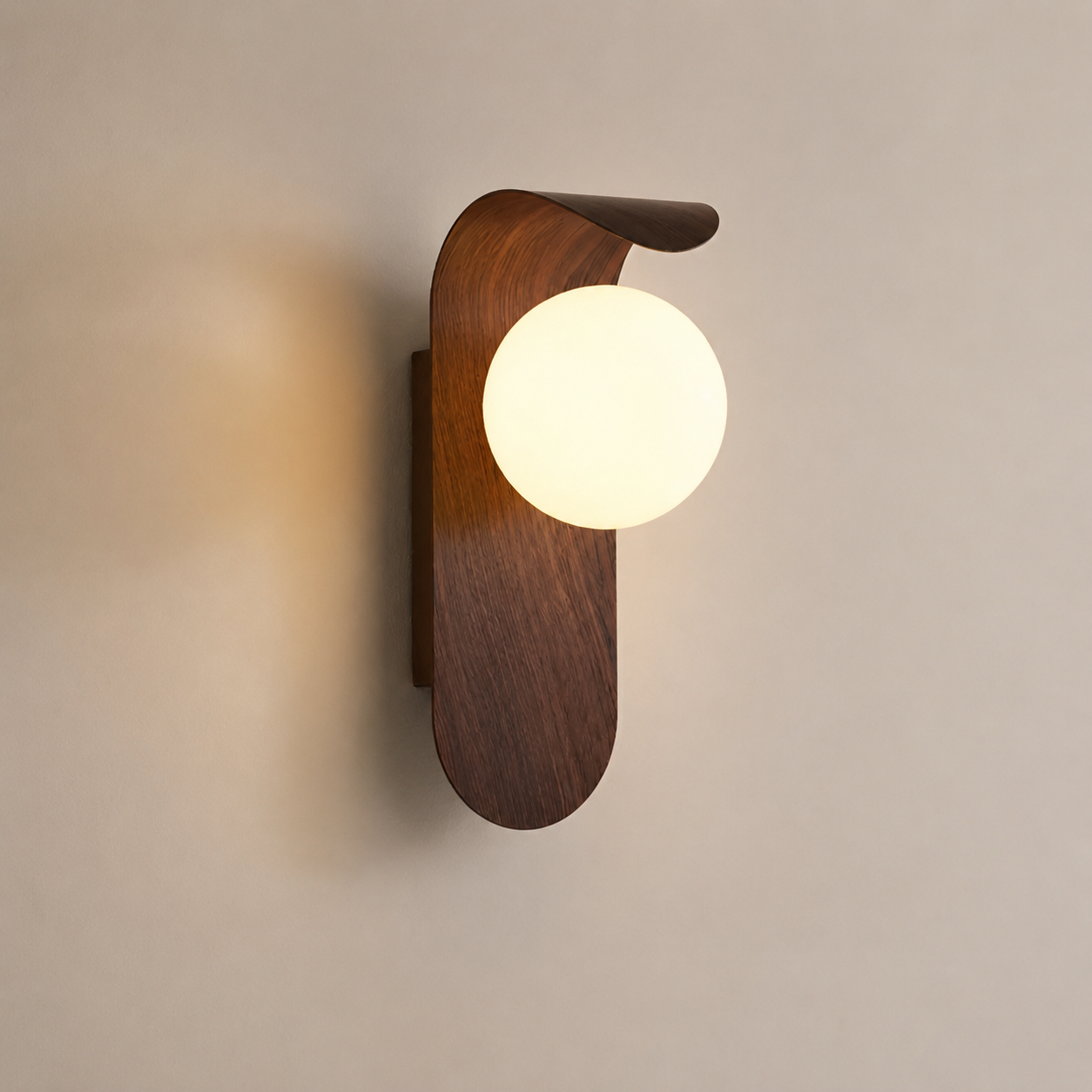Walnut wall sconce with frosted globe glowing on a neutral wall.