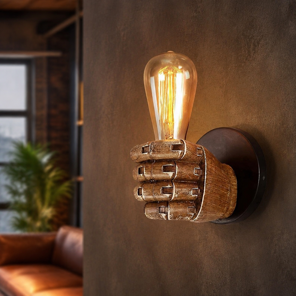 Sculptural resin hand wall sconce holding an exposed bulb.