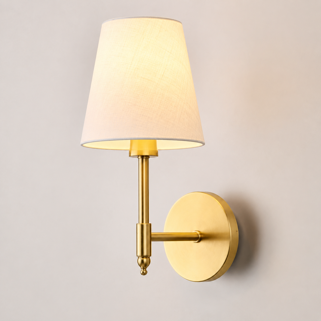 Gold wall sconce with white fabric shade displayed against a neutral background.