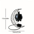 Moon shaped iron stand with hanging black ceramic cauldron and dimension labels.