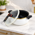 White enamel stock pot with glass lid tilted beside the open pot