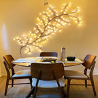 Willow vine fairy lights curve above a round dining table.