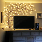 Willow vine fairy lights frame a television on a living room wall.