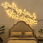 Willow vine fairy lights extend across the wall above a bed.