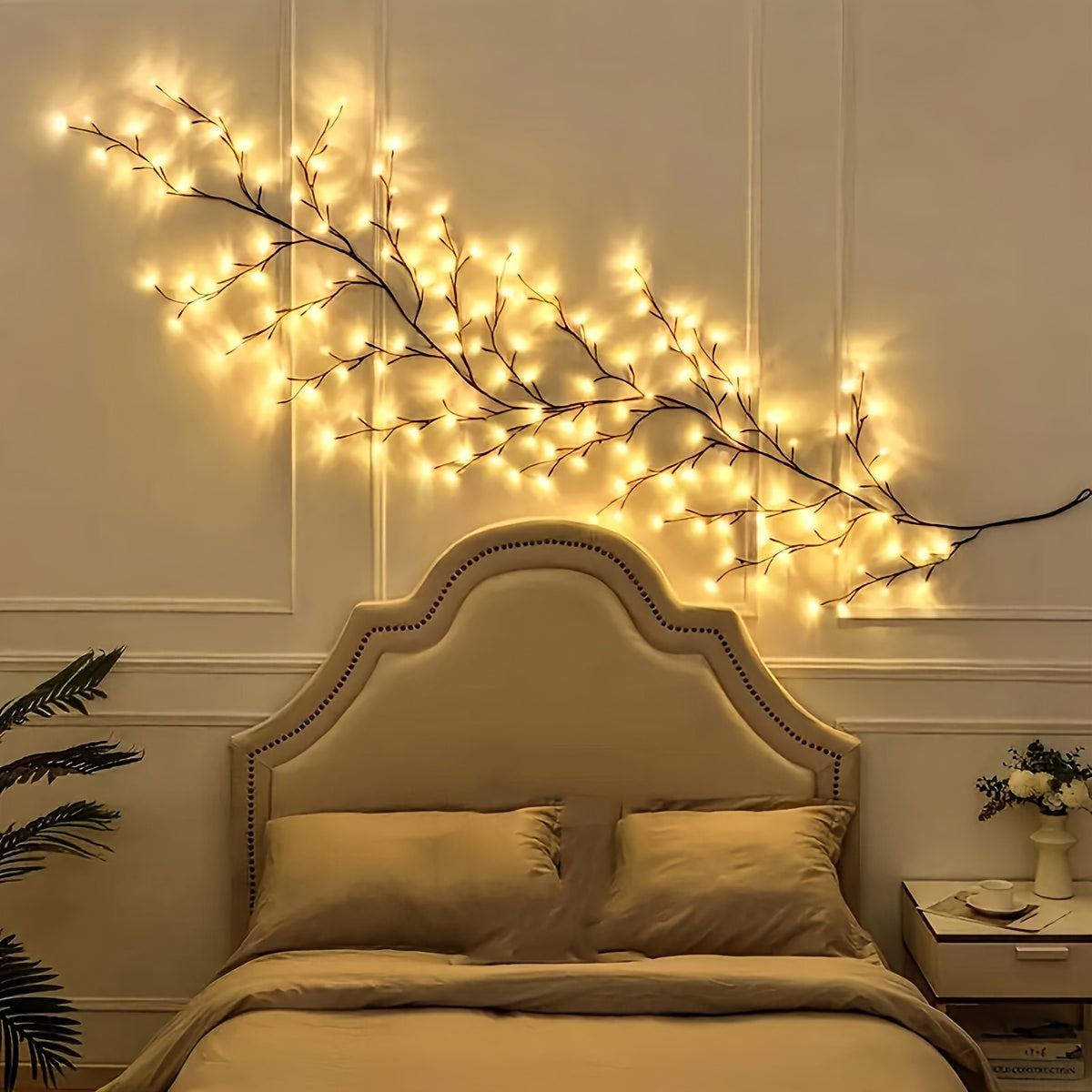 Willow vine fairy lights extend across the wall above a bed.