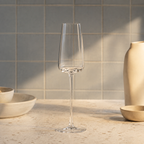 Champagne wine glass with tall narrow bowl on a softly lit kitchen counter