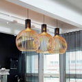 Wood pendant light arrangement with rounded slatted shades above a counter