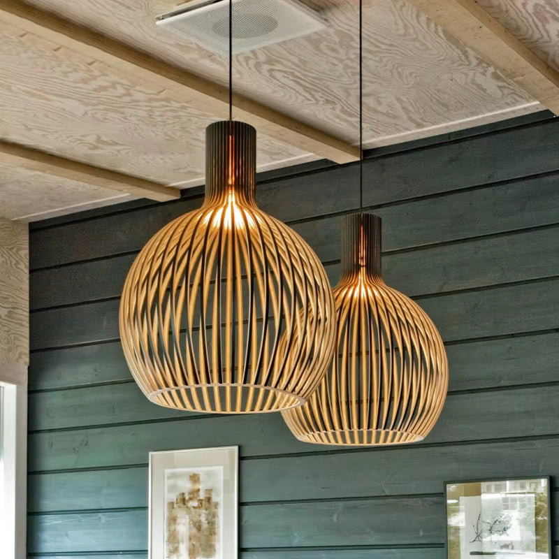 Wood pendant light pair hanging against a dark green wall