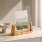 Vertical acrylic photo frame with pale wood base and a mountain landscape print.