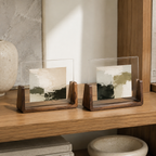 Two horizontal acrylic photo frame styles on an oak library shelf.