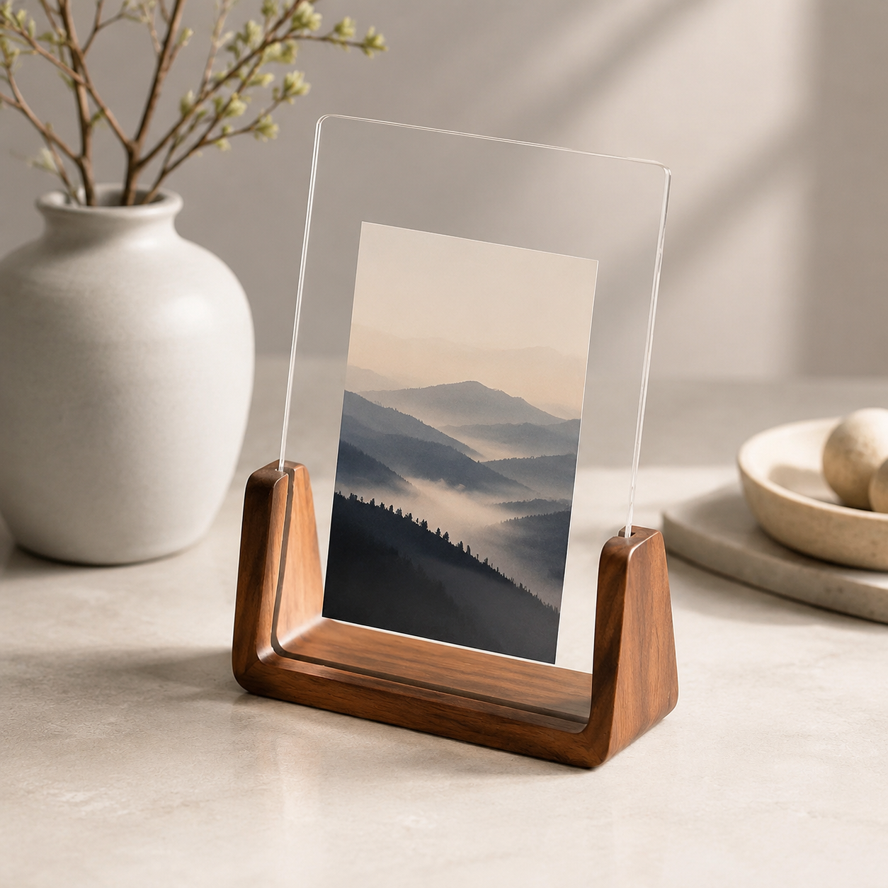 Vertical acrylic photo frame with walnut base and a layered mountain print.