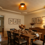 Orange layered ceiling light over a warm dining area.