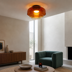 Orange glass ceiling light glowing in a contemporary interior.
