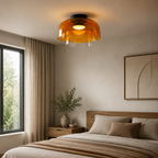 Orange three-layer ceiling light in a styled interior.