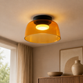 Orange single-layer glass ceiling light on white.