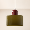 Dark green circular glass pendant light with a burgundy cap on a warm studio wall