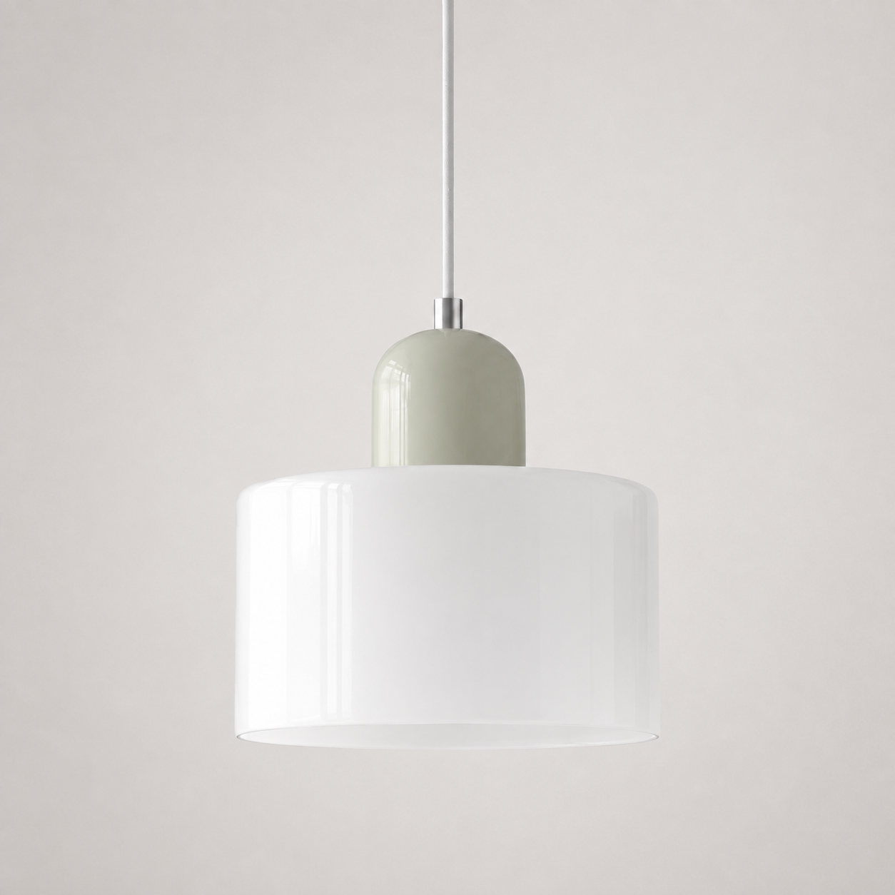 White circular glass pendant light with a pale sage cap on a light wall