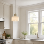 White circular glass pendant light glowing beside an American kitchen window