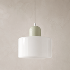 Close view of a white circular glass pendant light with a pale sage cap