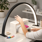 Black crescent moon LED desk lamp illuminating a manicure workspace.