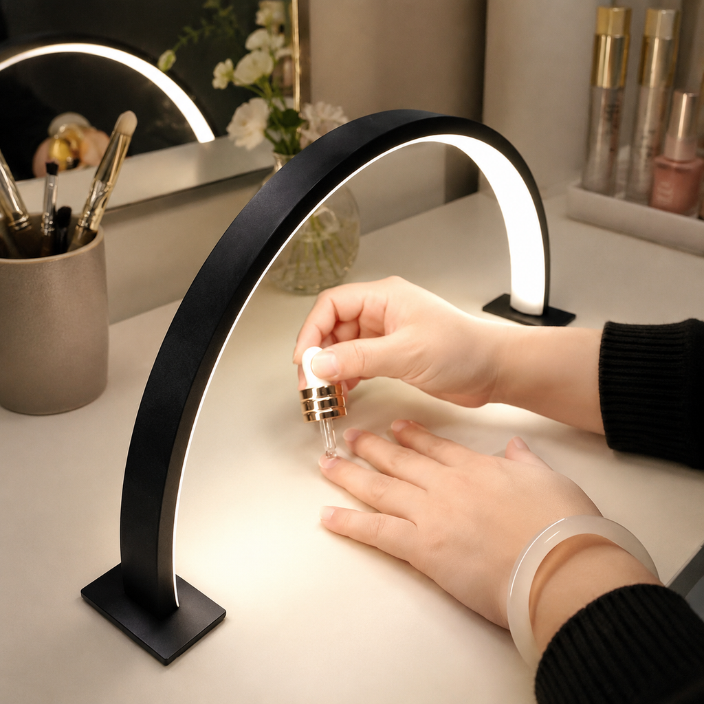 Black crescent moon LED desk lamp providing focused light for a manicure.